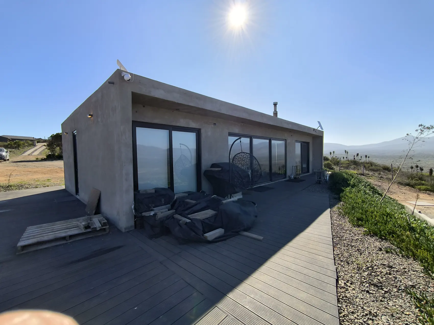 Casa de hormigón terminada, con ventanales corridos y vista al valle