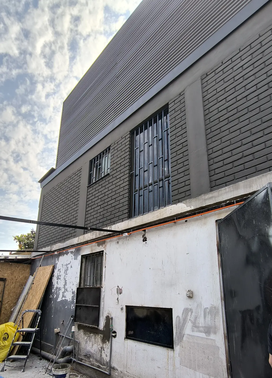 Muro de una casa antigua y, sobre él, el volumen nuevo autorizado por el permiso