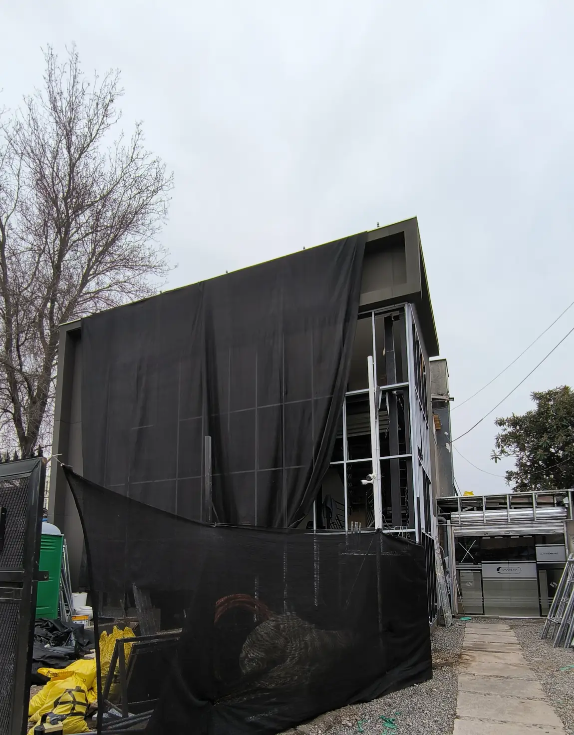El volumen nuevo en construcción, cubierto con malla negra, con la estructura metálica a la vista