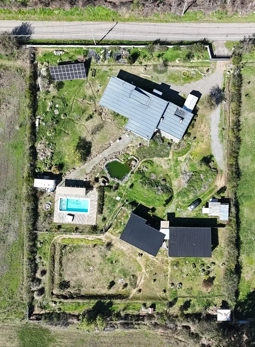 Vista cenital de la parcela: las dos viviendas, la piscina, la laguna y los deslindes