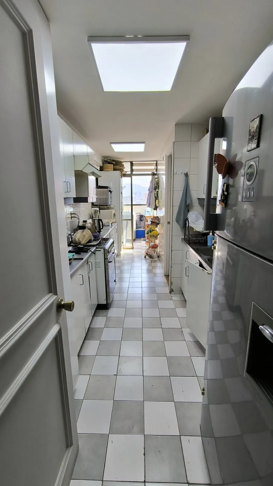 Cocina original del departamento: espacio angosto, cerrado, con pastelones y mobiliario antiguo