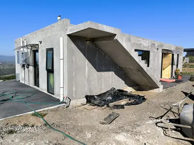 Casa Jaime en Los Molles construida: volumen de hormigón con escalera exterior y vista al valle