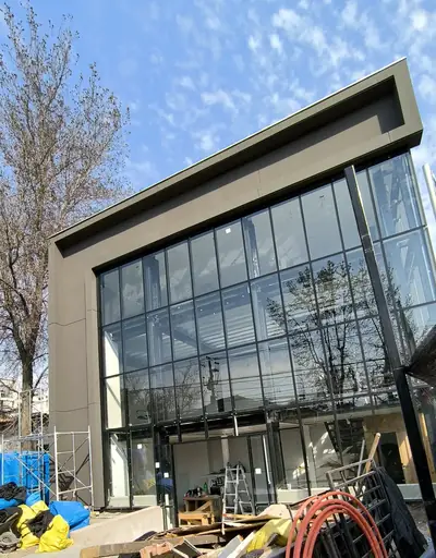 Oficina showroom en Ñuñoa: fachada vidriada de doble altura en ejecución