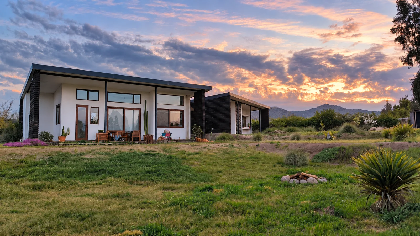 Casa VC en Pirque: vivienda construida, abierta al jardín y al paisaje al atardecer