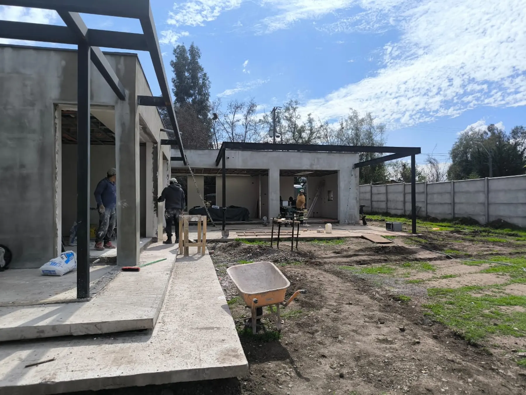 Casa VJ en obra: volúmenes de hormigón estucado y estructura de acero de la cubierta